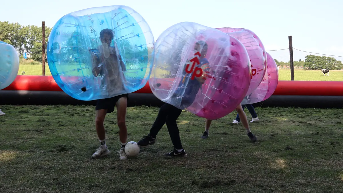 Collega&rsquo;s spelen bubbelvoetbal op het veld