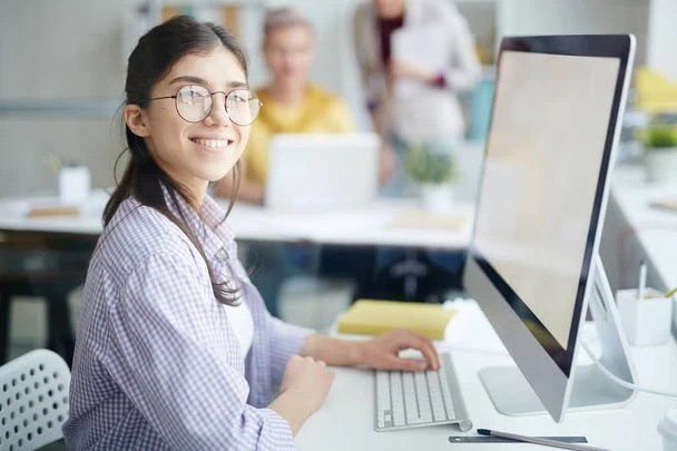 stock-photo-smiling-student-office-manager-looking-camera-while-sitting-desk-front